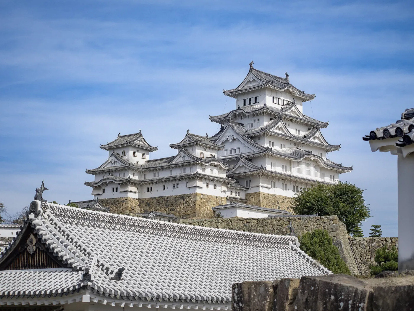Himeji Castle keep seen from the city with autumn foliage in Himeji, Japan