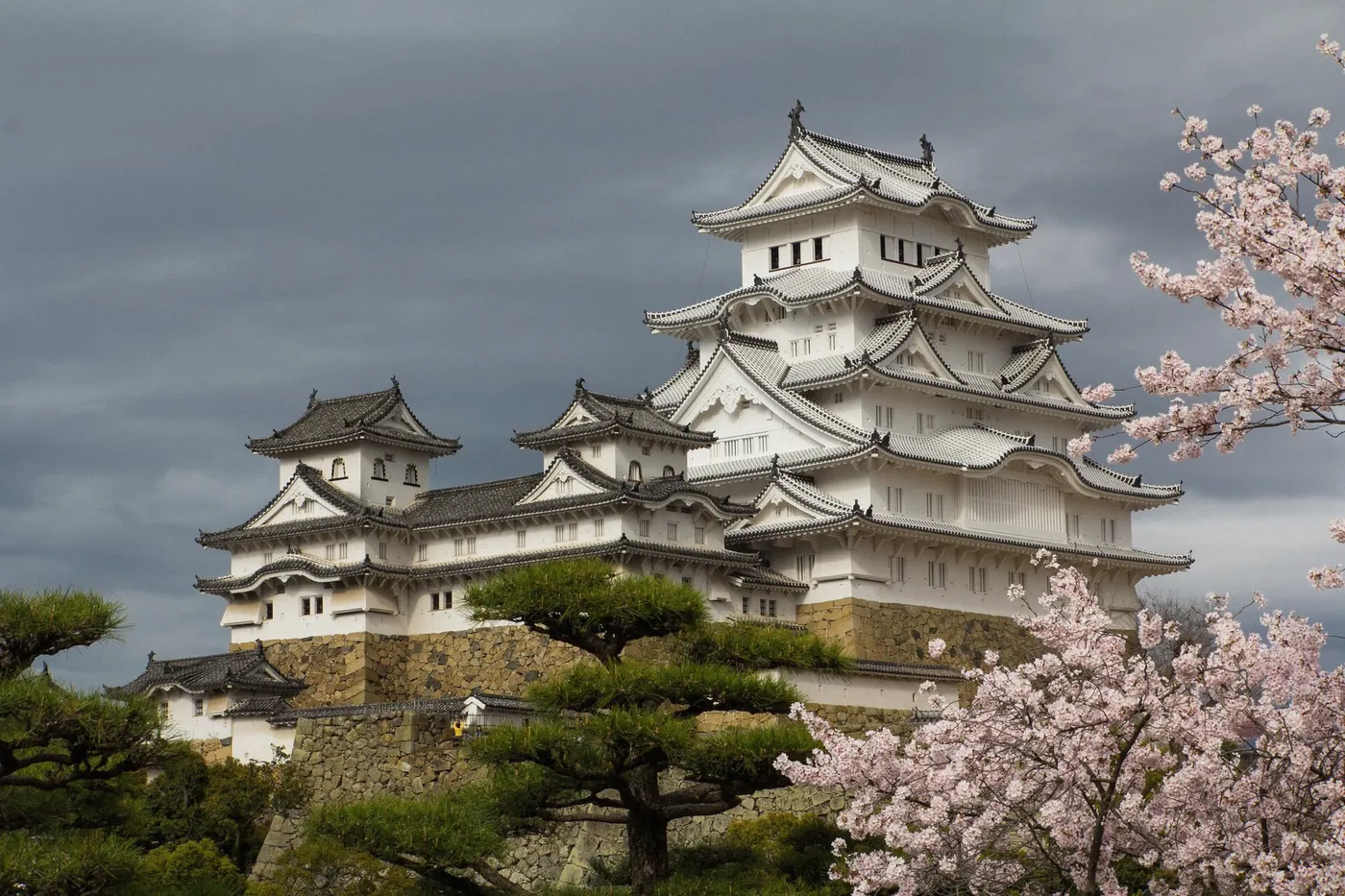 Stone base and wooden walls of Himeji Castle keep seen from below in Japan